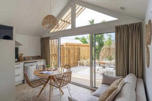 a kitchen and living room with a table and chairs at Camping 4 étoiles - Piscine - cbgcaig in Notre-Dame-de-Monts