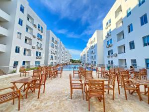 a row of chairs and tables in front of buildings at apartamento con alma 888 in Coveñitas