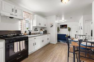 a kitchen with white cabinets and a black stove at Fun Family getaway - NYC & NWK w free parking in Newark +12 photos