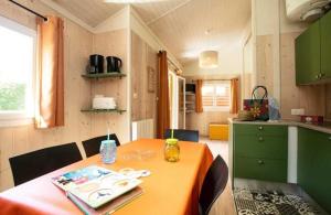 una piccola cucina con tavolo in una casetta di Camping 5 étoiles - Piscine - eeceff a Le Bourg-dʼOisans