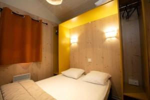 una camera con due letti e una parete gialla di Camping 5 étoiles - Piscine - eeceff a Le Bourg-dʼOisans