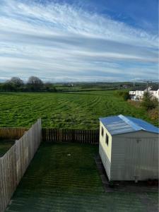 ein kleines Gebäude mit einem Feld im Hintergrund in der Unterkunft Tildara Terrace in Portstewart