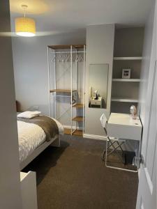 ein Schlafzimmer mit einem Bett, einem Schreibtisch und einem Spiegel in der Unterkunft Tildara Terrace in Portstewart + 19 Fotos