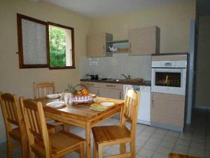 a kitchen with a wooden table with chairs and a dining room at ZEcamping 4 étoiles pataugeoire piscine chiens acceptés tente 25m2 in Meyronne