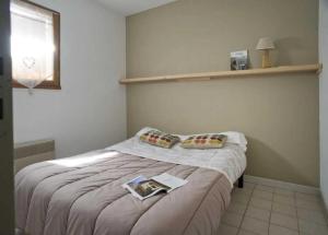 a bedroom with a bed with a book on it at ZEcamping 4 étoiles pataugeoire piscine chiens acceptés tente 25m2 in Meyronne