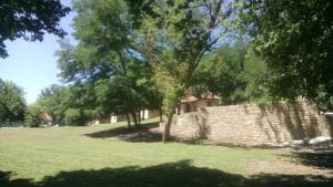 a house in a field with trees and a brick wall at ZEcamping 4 étoiles pataugeoire piscine chiens acceptés tente 25m2 in Meyronne +40 photos