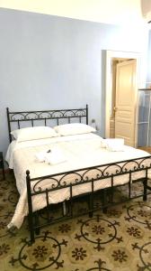 una camera da letto con un letto grande con lenzuola bianche di Saranton House a Catania