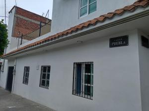 a white building with a sign on the side of it at Casa Naty in Mexico City