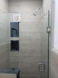 a shower with a glass door and a sink at Casa Naty in Mexico City