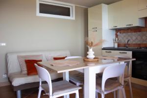 a kitchen with a table and chairs and a couch at Perla d'Orlando in Capo dʼOrlando