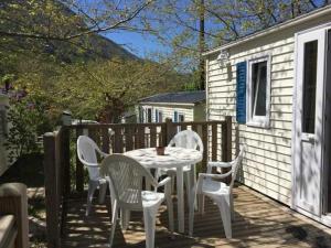 un tavolo e sedie su una terrazza con una casa di Camping 3 étoiles - ccbbbda a Castellane