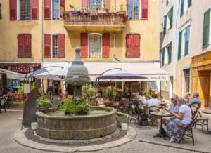 un gruppo di persone sedute ai tavoli attorno a una fontana di Camping 3 étoiles - ccbbbda a Castellane Altre 26 foto