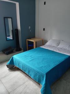 a bedroom with a bed with a blue blanket on it at Casa Naty in Mexico City +15 photos