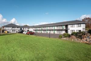 a large building with a green lawn in front of it at Travel Air Motel in Auckland