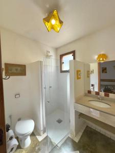Un baño con inodoro, ducha y lavabo. en Pousada Fecho da Serra, en Capitólio 59 fotos más