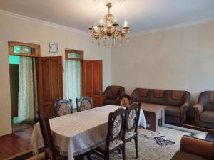 a dining room with a table and chairs and a chandelier at Guest house maka in Gonio