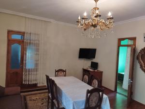 a dining room with a table and a chandelier at Guest house maka in Gonio