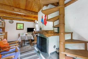 a living room with a fireplace and wooden ceilings at Rustico Savinera - Happy Rentals in San Carlo