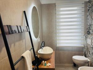 a bathroom with a white sink and a toilet at Golden House by ApartSuite in Chioggia
