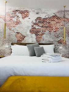 a bed in a room with a brick wall at Golden House by ApartSuite in Chioggia
