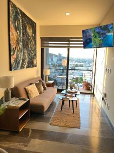 una sala de estar con un sofá y una mesa en Luxury, security, infinity pool, view, centric, en Miravalle
