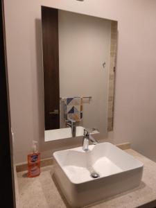 Un lavabo blanco en un baño con espejo. en Luxury, security, infinity pool, view, centric, en Miravalle 24 fotos más