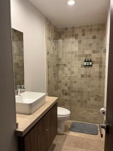 Un baño con lavabo, inodoro y ducha. en Luxury, security, infinity pool, view, centric, en Miravalle