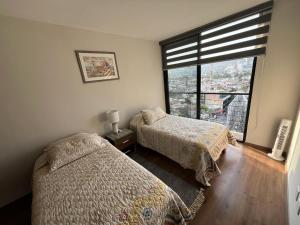 Un dormitorio con dos camas y una gran ventana. en Luxury, security, infinity pool, view, centric, en Miravalle