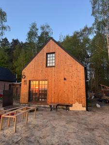 an orange barn with a window and a bench at LESNA 41a - Nowoczesna Stodoła w stylu skandynawskim in Dobrcz