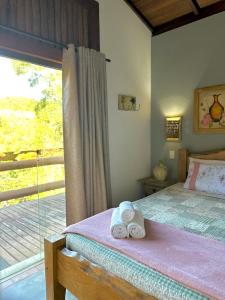 Un dormitorio con una cama con una toalla encima. en Pousada Fecho da Serra, en Capitólio