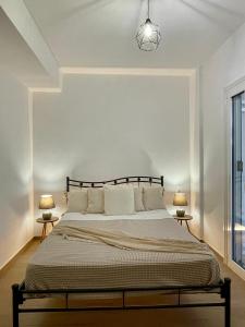 a bedroom with a large bed with two lamps at Aura Seaside Afrathias in Kalamaki