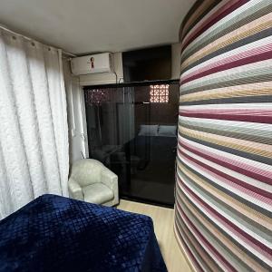 a room with a wall with a table and a chair at Loft Lux SM 11 (Smart TV, Ar condicionado, Cozinha) in Chapecó