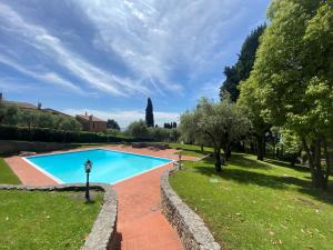 a swimming pool in a yard with trees and grass at [Exclusive Villa Punta San Vigilio] in Garda