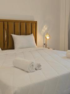 une chambre avec un lit blanc avec des serviettes dessus dans l'établissement Natural Blue Suites-Canal d'Amour Retreat, à Sidari