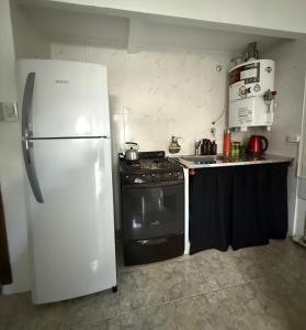 a kitchen with a white refrigerator and a stove at Departamento in Mar del Plata