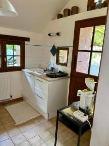 a kitchen with a sink and a stove top oven at La petite maison in Saint-Mars-dʼOutillé