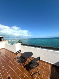 ein Tisch und zwei Stühle auf einem Balkon mit Blick auf das Meer in der Unterkunft Hermoso loft frente al mar vista increíble in Cancún