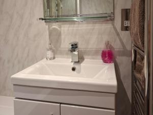 a white sink in a bathroom with a mirror at Black Stair Room - En Suite in Helensburgh