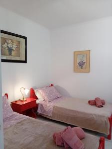 a bedroom with two beds and a red table at Κυκλαδίτικο διαμέρισμα in Andros