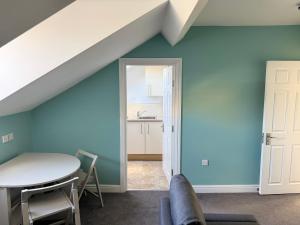 a dining room with blue walls and a table at Aaron Wise - 09 Coldstream Studios in Cardiff