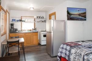 a kitchen with a refrigerator and a table in a room at Baby Bear - A delightful studio style property in the perfect central location! in Big Bear Lake +1 photo
