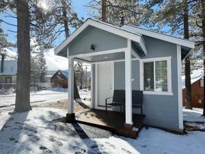 a small shed with a porch in the snow at Baby Bear - A delightful studio style property in the perfect central location! in Big Bear Lake