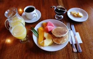 un piatto di cibo con pancake e frutta e una tazza di caffè di Hotel El Atardecer a Monteverde Costa Rica Altre 30 foto