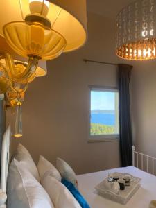 a bedroom with a bed with a yellow chandelier at Perla Hvar ApartHotel in Ivan Dolac