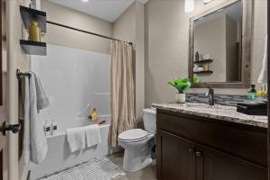 a bathroom with a toilet and a sink and a mirror at Winston's Luxurious Retreat in Coeur d'Alene +42 photos