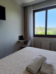 una camera con un letto con finestra e un computer portatile di Habitación 1 con vistas a Bilbao