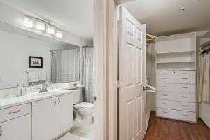 a white bathroom with a toilet and a sink at Courtyard Oasis - Drift into Downtown Comfort with Pool Access in West Palm Beach