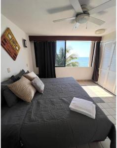a bedroom with a black bed with a view of the ocean at Hermoso departamento frente al mar vista increíble in Cancún +15 photos
