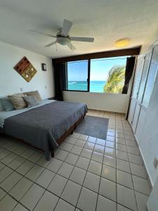 a bedroom with a bed and a view of the ocean at Hermoso departamento frente al mar vista increíble in Cancún