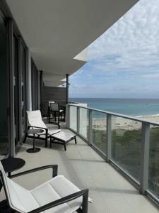 a balcony with chairs and a view of the ocean at Amrit Resort - Bask in Rare Oceanfront Luxury with Stunning Views in Riviera Beach